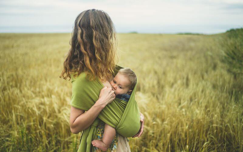 bébé qui allaite en écharge de portage